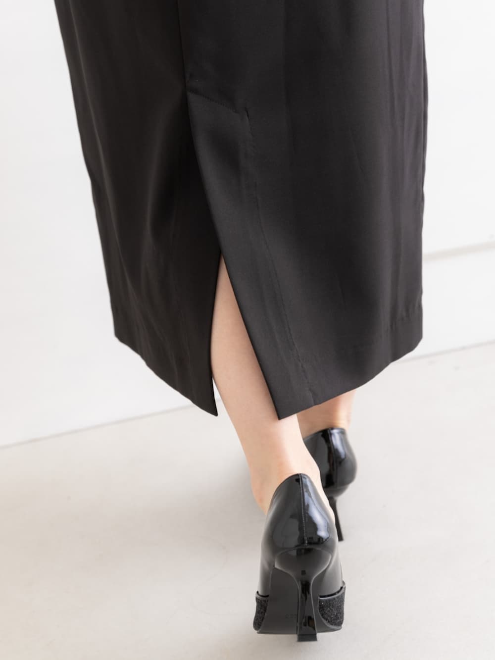 ベージュ系のクラッチバッグ、ブラック系のドレスを着用したレディースの春コーディネートの10枚目の写真