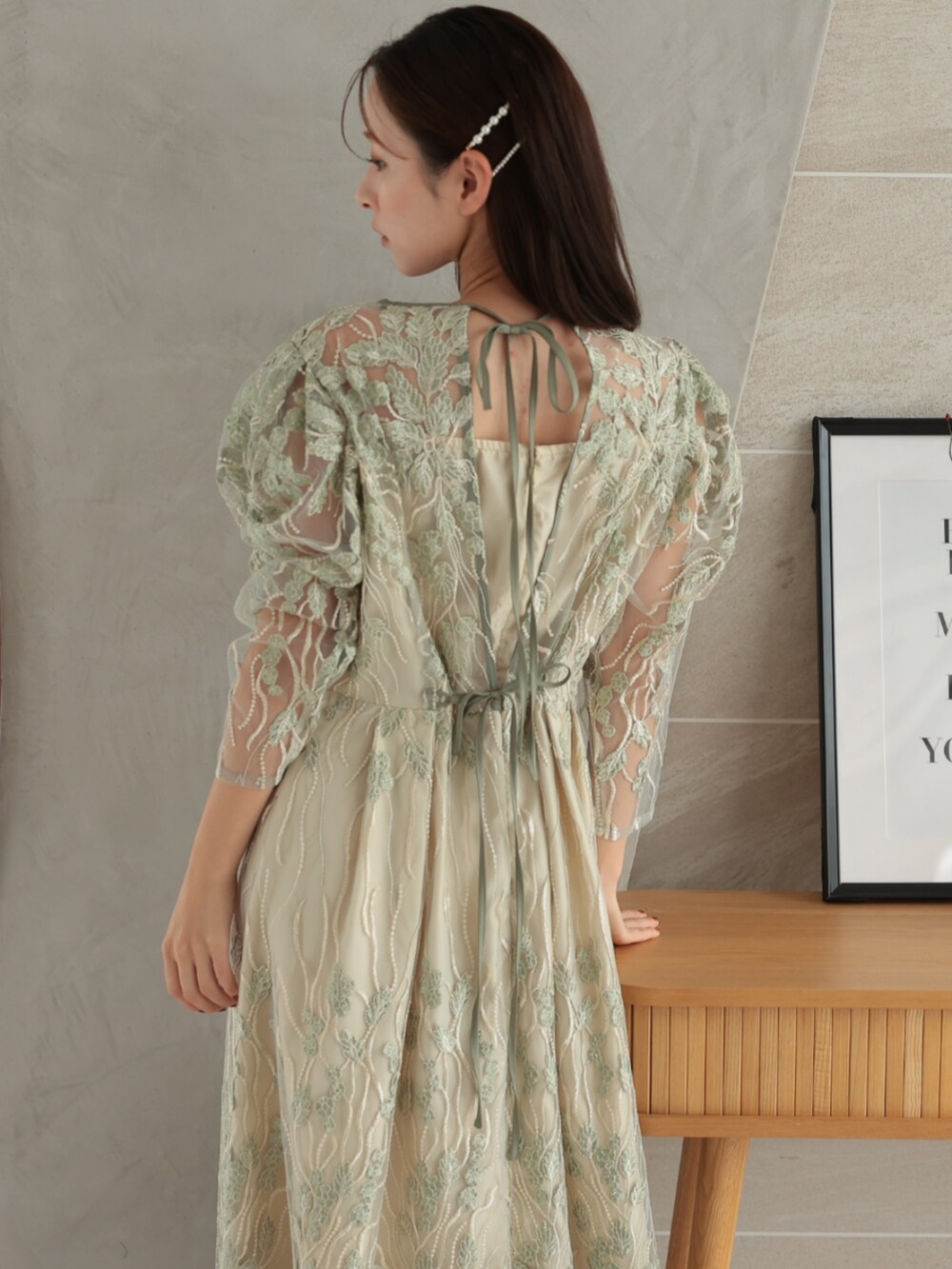 グリーン系のドレスを着用したレディースの冬コーディネートの3枚目の写真