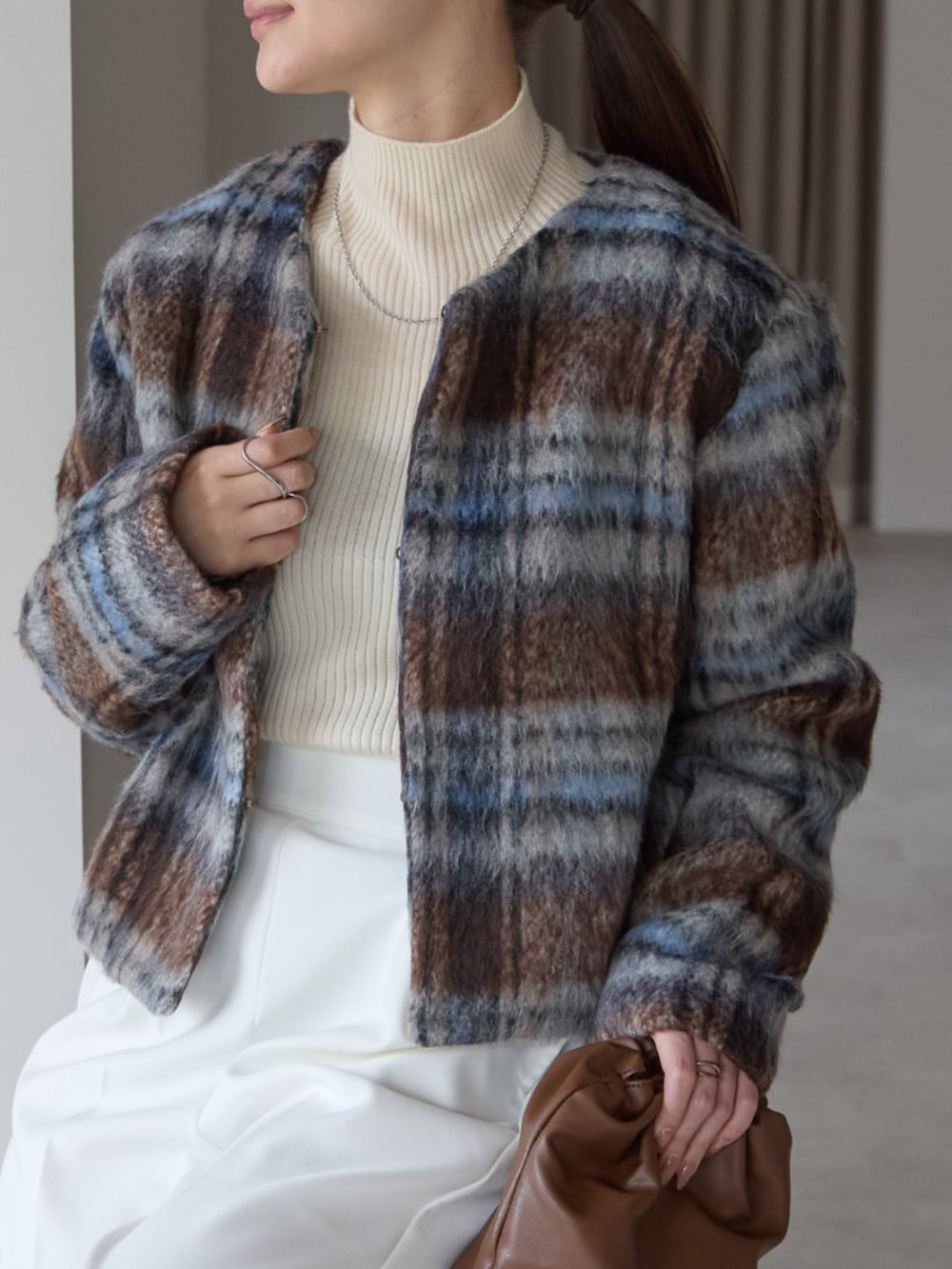 ブラウン系のノーカラージャケットを着用したレディースの秋コーディネートの3枚目の写真