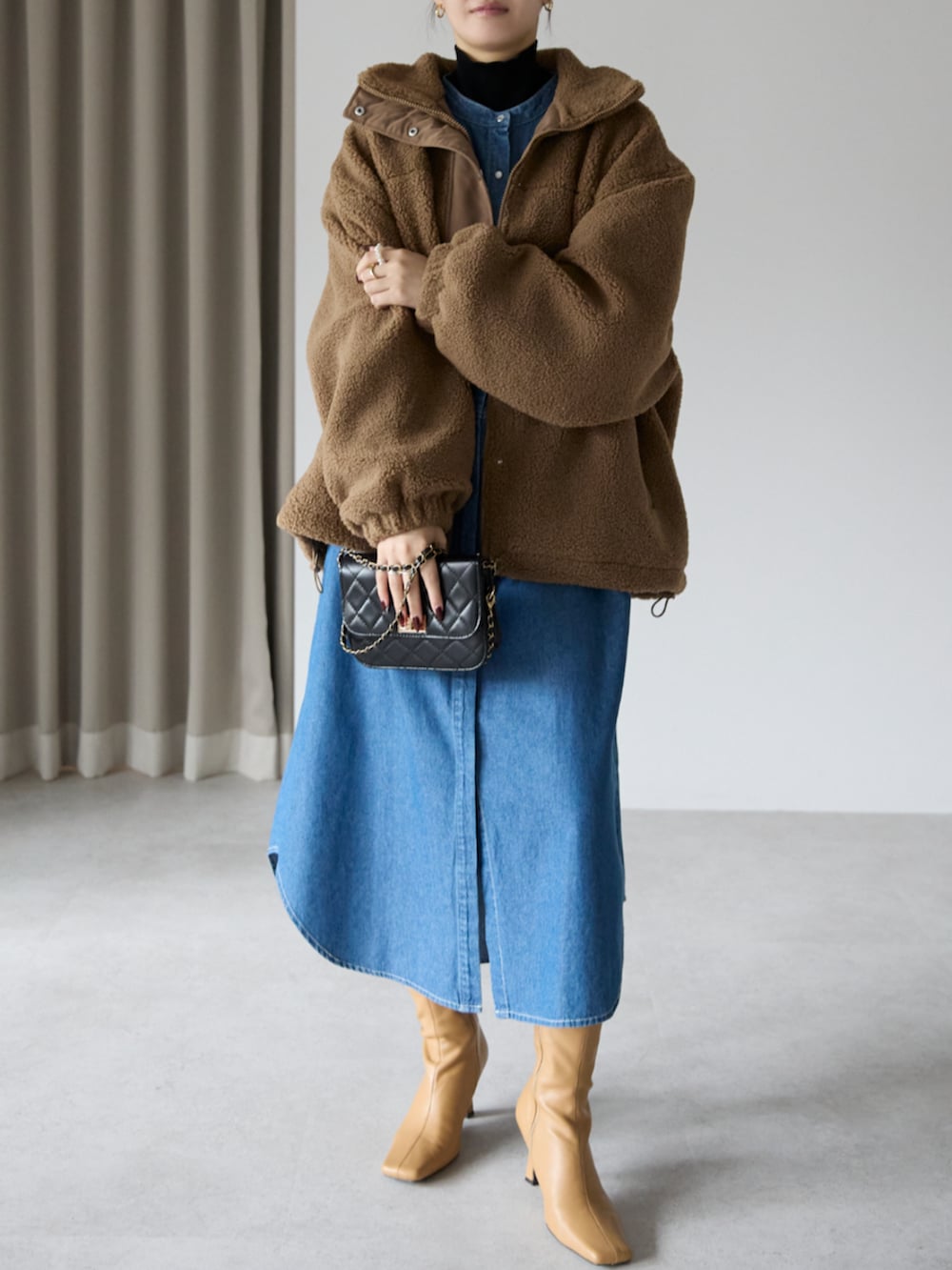 ブラウン系のブルゾン、ブルー系のシャツワンピースを着用したレディースの冬コーディネートの2枚目の写真