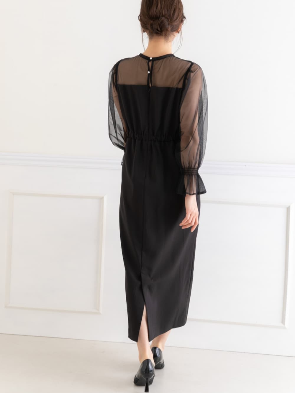 ベージュ系のクラッチバッグ、ブラック系のドレスを着用したレディースの春コーディネートの4枚目の写真