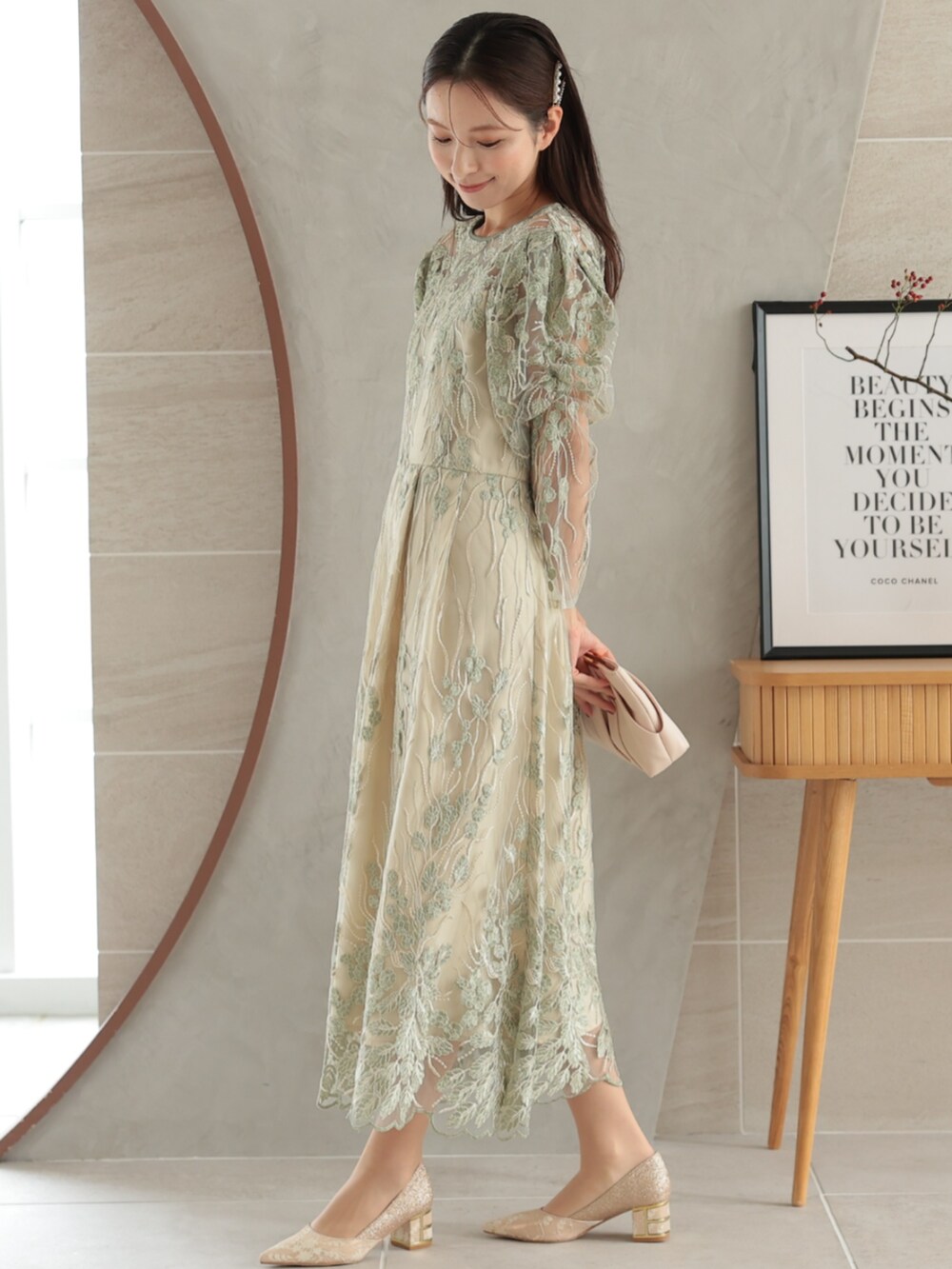 グリーン系のドレスを着用したレディースの冬コーディネートの2枚目の写真