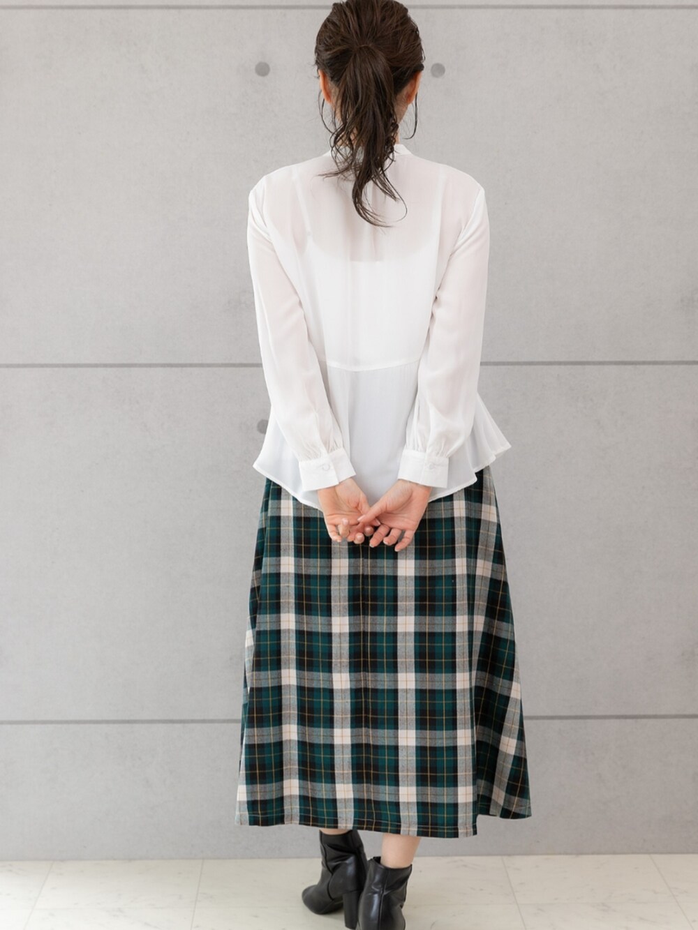 グリーン系のスカート、ホワイト系のシャツ/ブラウスを着用したレディースの秋コーディネートの2枚目の写真