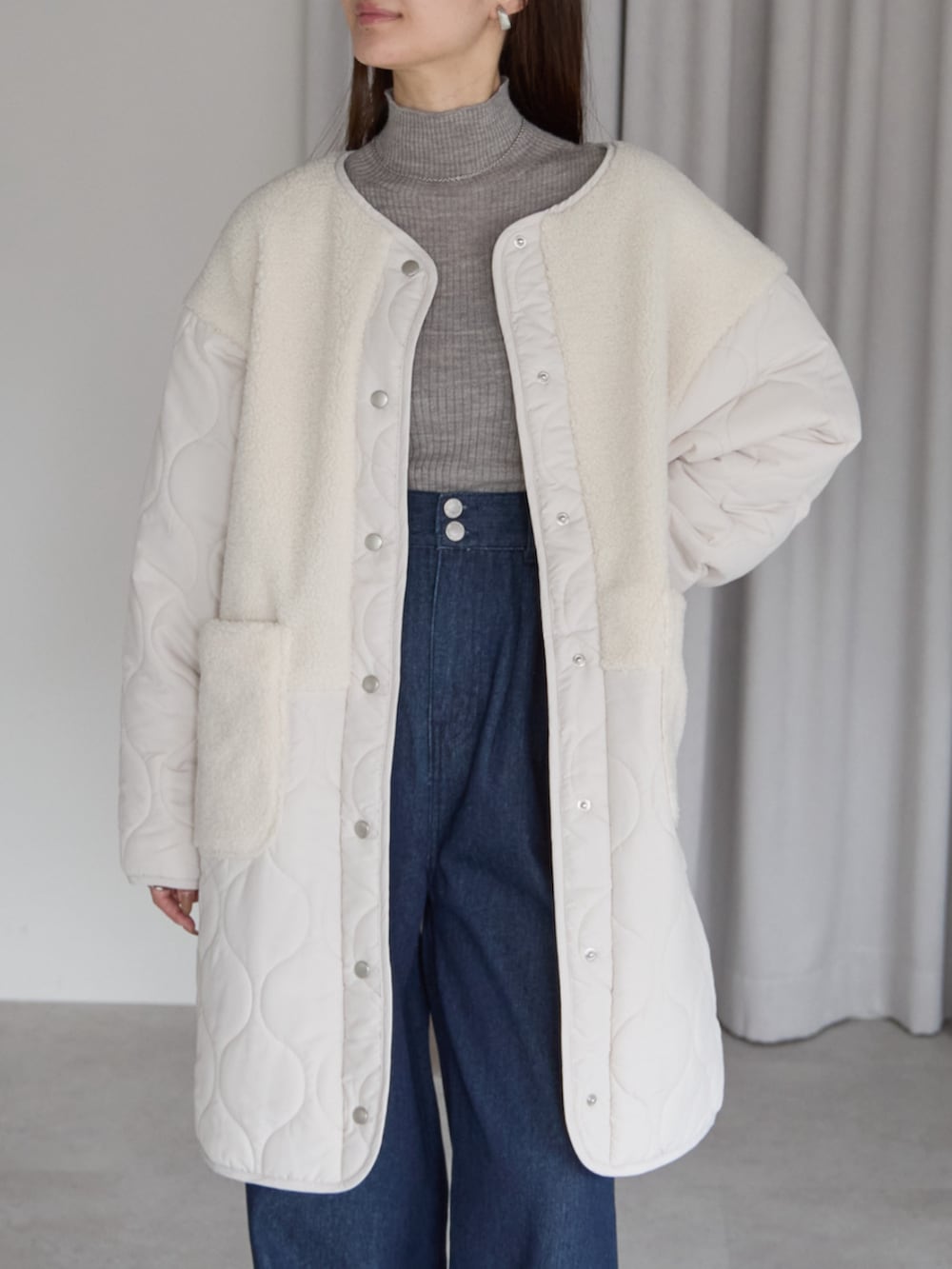 ブルー系のデニムパンツ、ホワイト系のノーカラーコートを着用したレディースの冬コーディネートの3枚目の写真