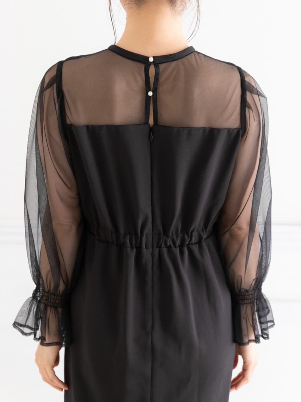 ベージュ系のクラッチバッグ、ブラック系のドレスを着用したレディースの春コーディネートの8枚目の写真