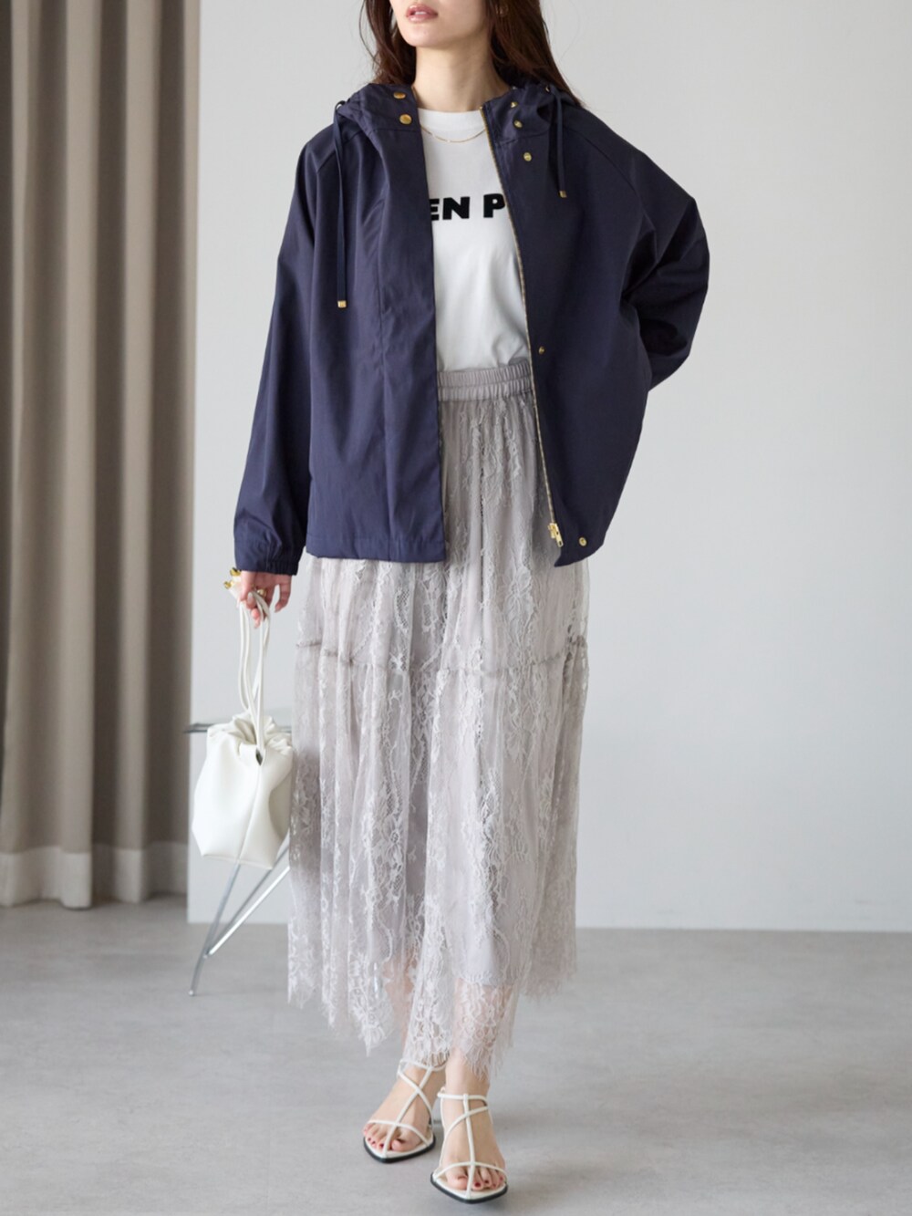 グレー系のスカート、ブルー系のマウンテンパーカーを着用したレディースの冬コーディネートの2枚目の写真