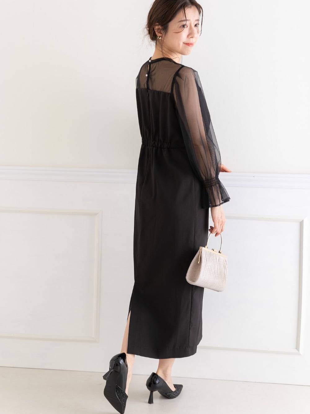ベージュ系のクラッチバッグ、ブラック系のドレスを着用したレディースの春コーディネートの5枚目の写真