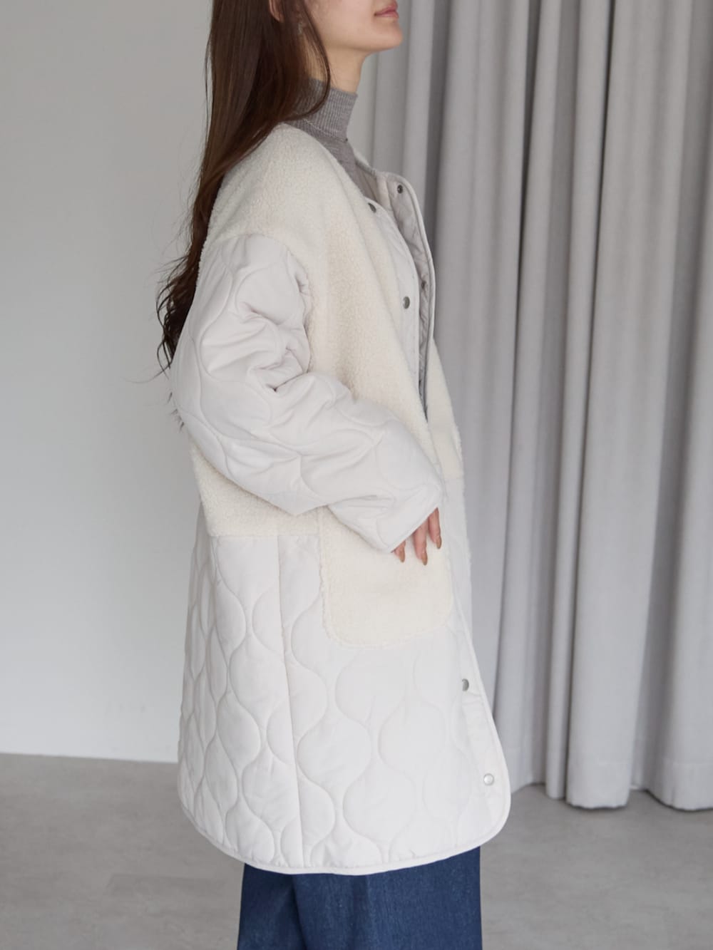 ホワイト系のノーカラーコートを着用したレディースの秋コーディネートの3枚目の写真