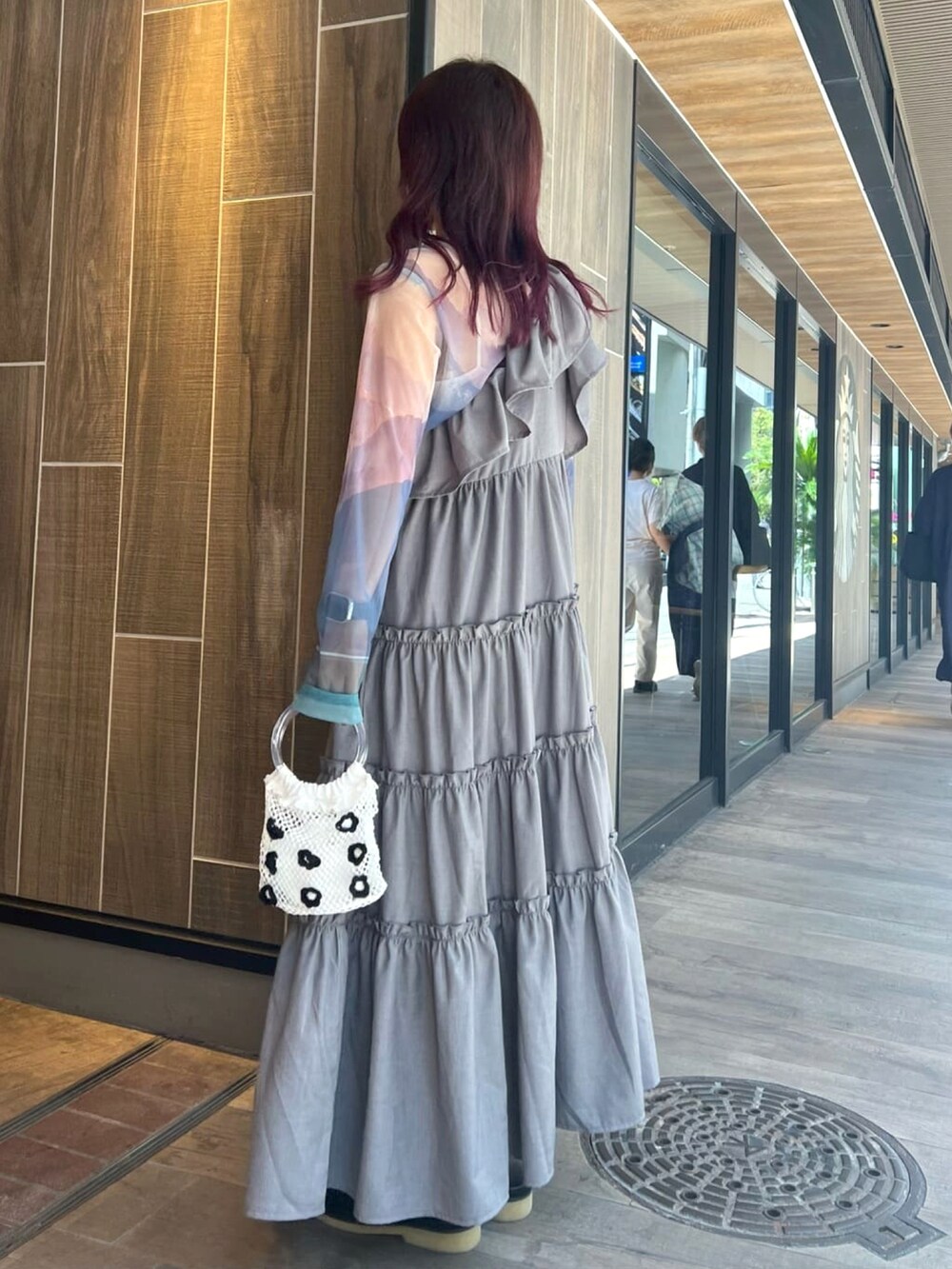 グレー系のワンピース、ブルー系のTシャツ/カットソー、ホワイト系のハンドバッグを着用したレディースの秋コーディネートの3枚目の写真