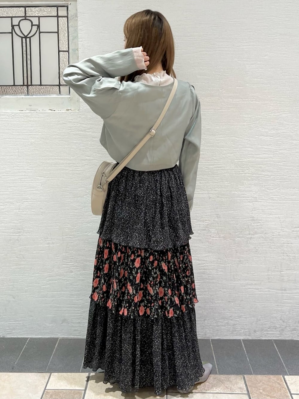 グリーン系のカーディガン/ボレロ、ホワイト系のTシャツ/カットソー、ブラック系のスカートを着用したレディースの春コーディネートの2枚目の写真