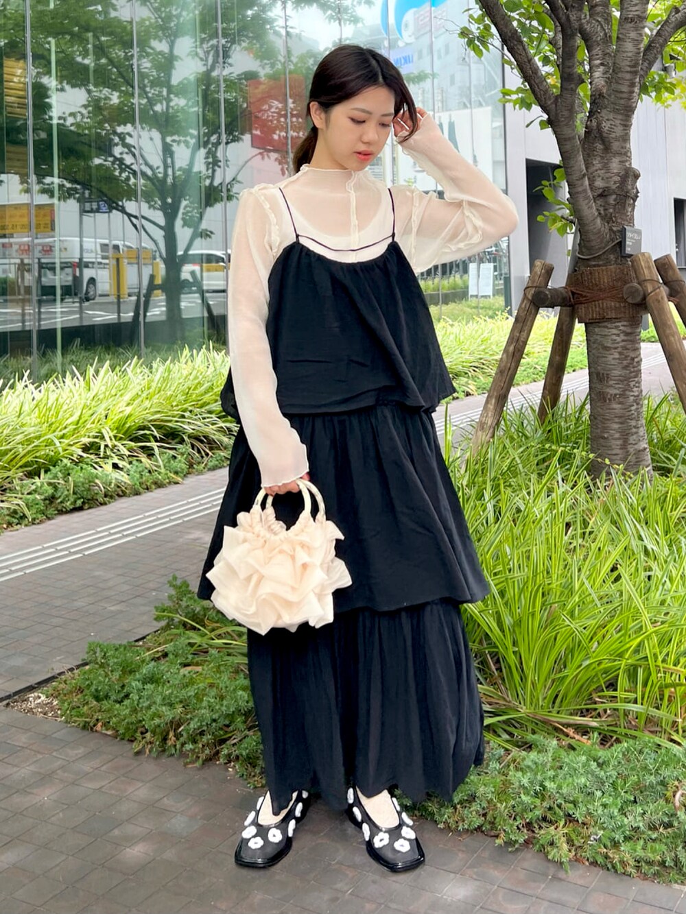 ブラック系のワンピース、ホワイト系のTシャツ/カットソー、ホワイト系のハンドバッグを着用したレディースの夏コーディネートの2枚目の写真