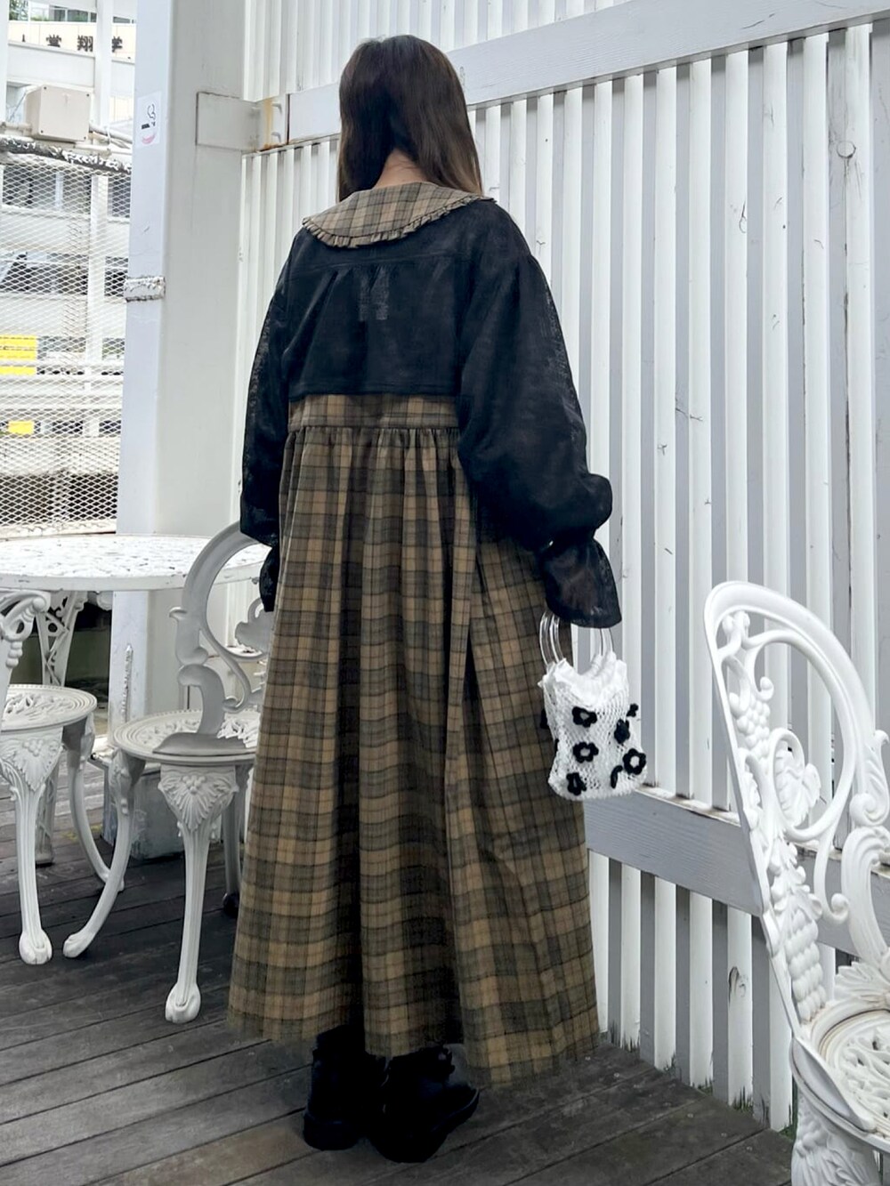 イエロー系のワンピース、ブラック系のシャツ/ブラウス、ホワイト系のハンドバッグを着用したレディースの夏コーディネートの2枚目の写真