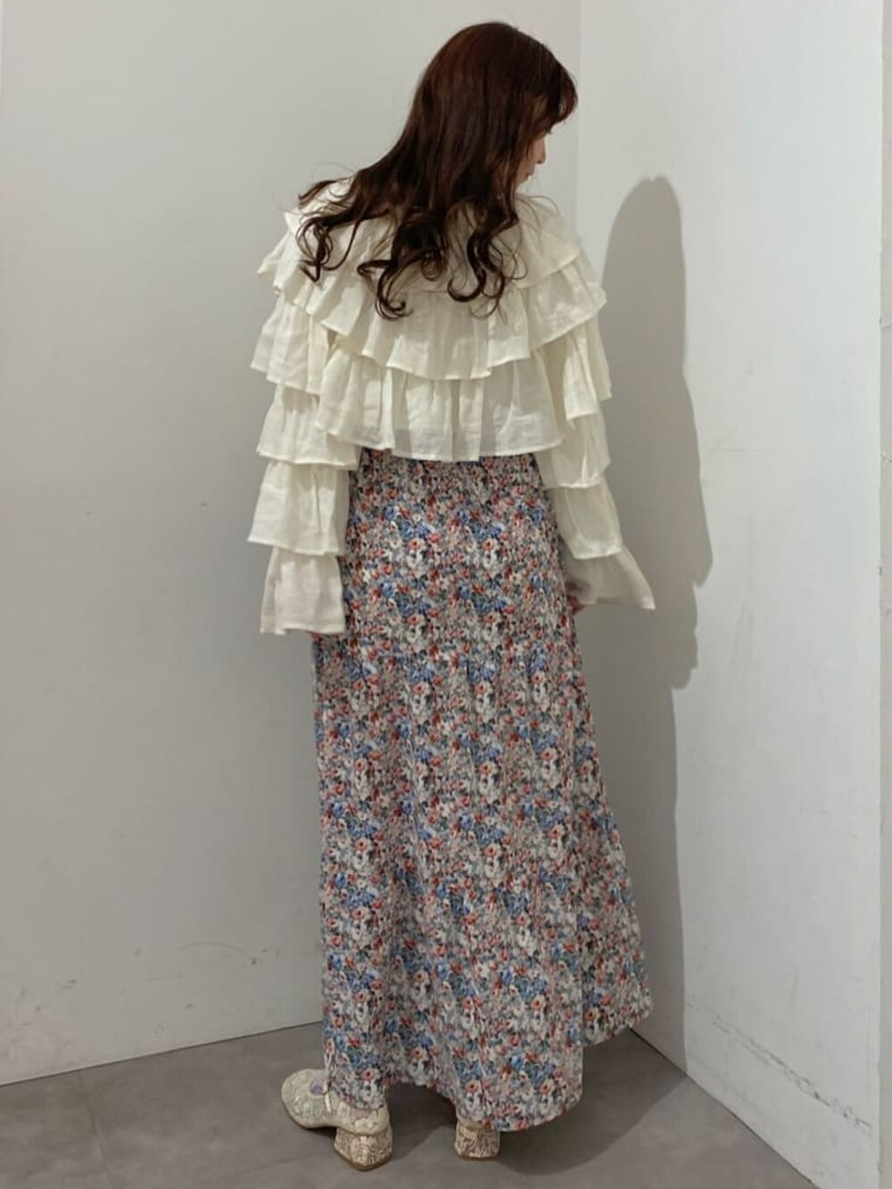 ホワイト系のカーディガン/ボレロ、ピンク系のワンピース、ホワイト系のパンプスを着用したレディースの冬コーディネートの2枚目の写真