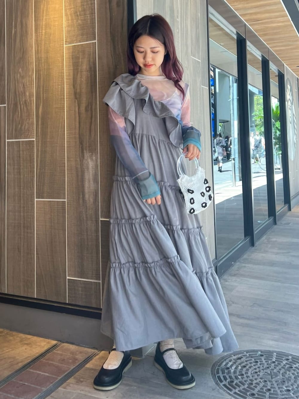 グレー系のワンピース、ブルー系のTシャツ/カットソー、ホワイト系のハンドバッグを着用したレディースの秋コーディネートの2枚目の写真