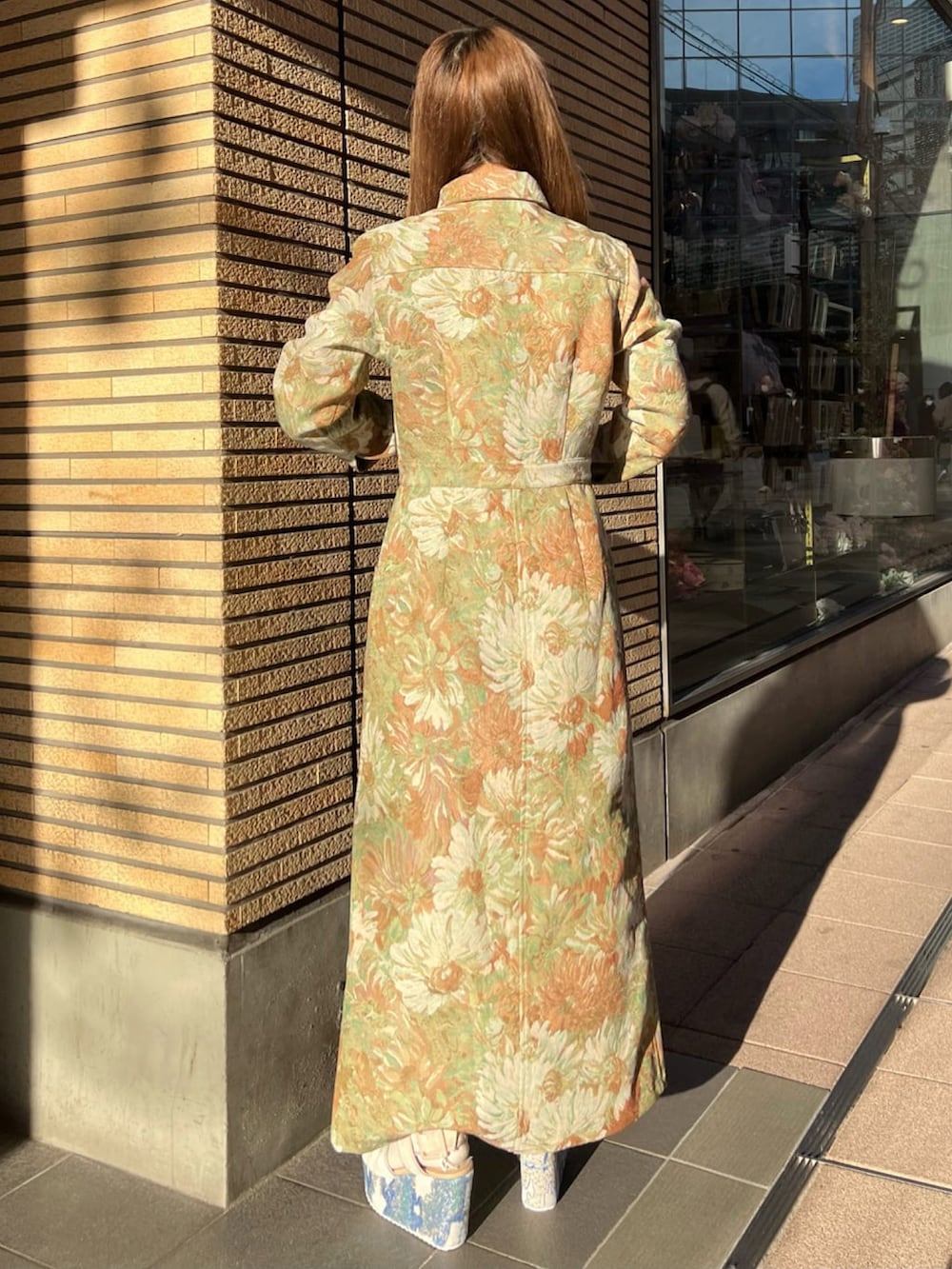 イエロー系のワンピース、ブルー系のサンダル、その他のイヤリングを着用したレディースの冬コーディネートの2枚目の写真