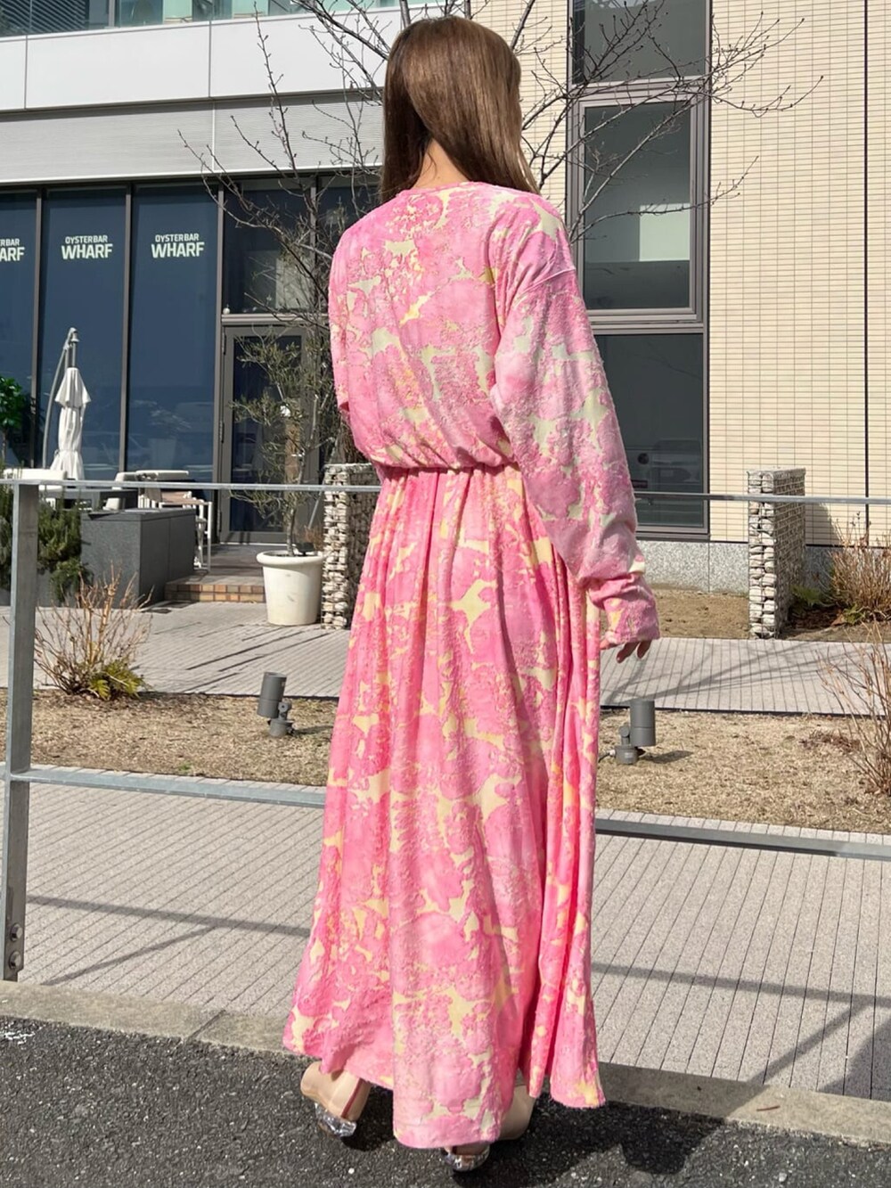 ピンク系のワンピース、ベージュ系のパンプスを着用したレディースの冬コーディネートの2枚目の写真