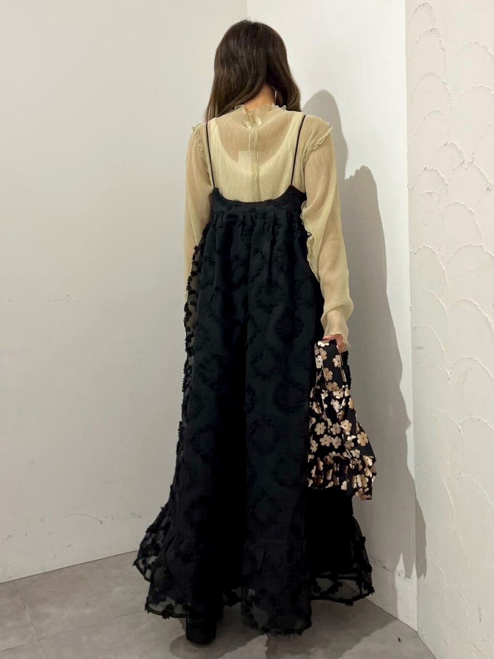 ブラック系のワンピース、グリーン系のTシャツ/カットソー、ブラック系のハンドバッグを着用したレディースの夏コーディネートの2枚目の写真