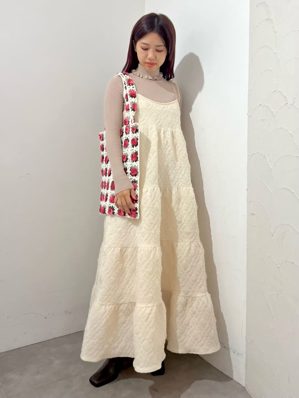 ホワイト系のワンピース、ベージュ系のニット/セーター、ブラウン系のブーツを着用したレディースの秋コーディネートの2枚目の写真