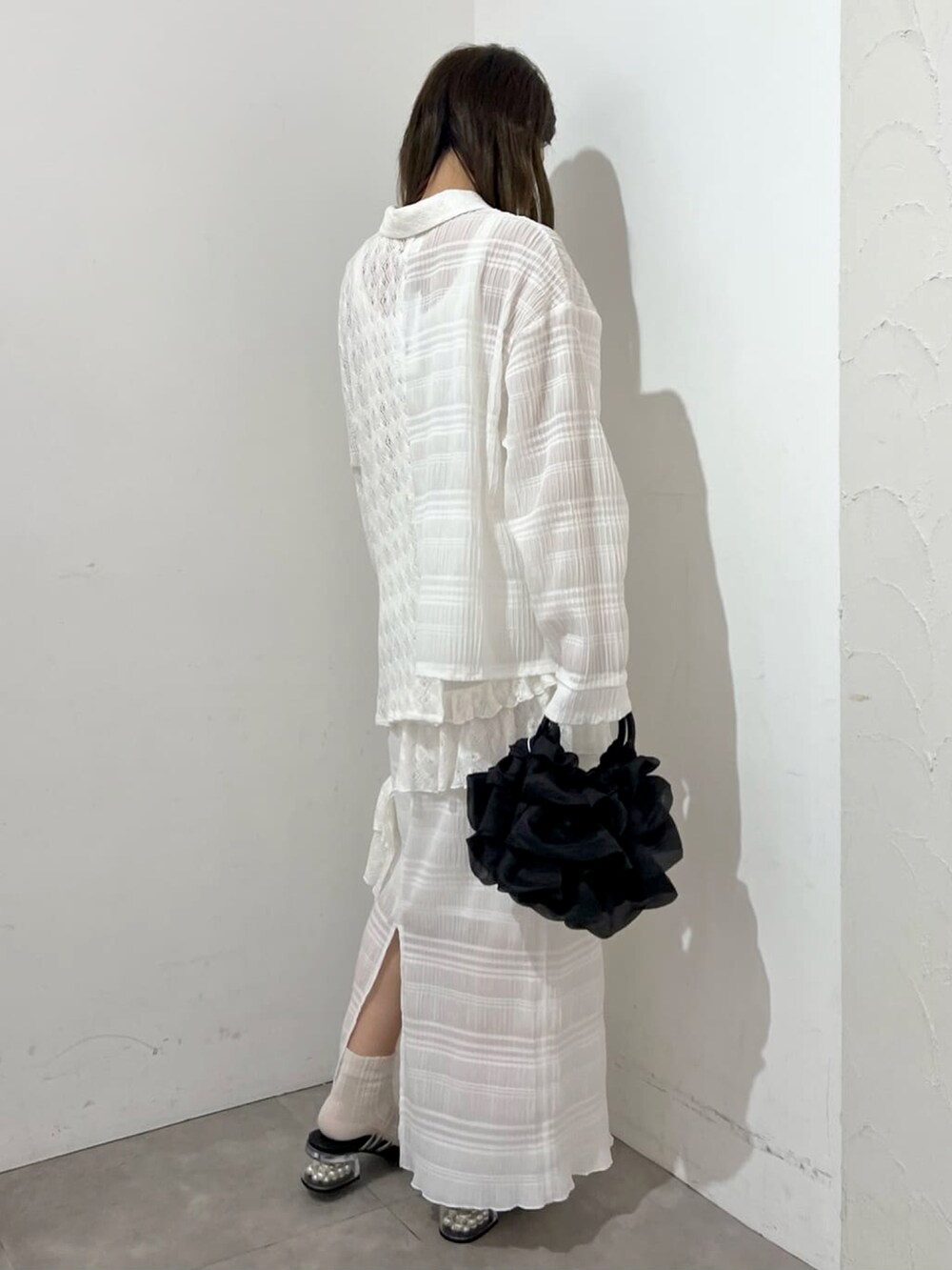 ホワイト系のシャツ/ブラウス、ホワイト系のスカート、ブラック系のハンドバッグを着用したレディースの夏コーディネートの2枚目の写真