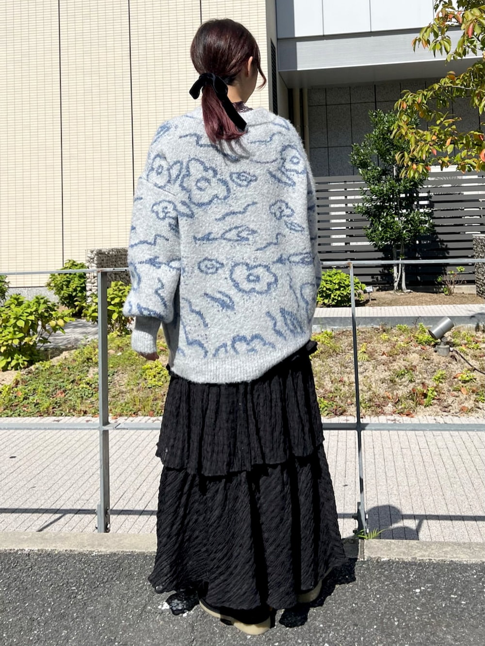 グレー系のカーディガン/ボレロ、グレー系のTシャツ/カットソー、ブラック系のスカートを着用したレディースの秋コーディネートの2枚目の写真