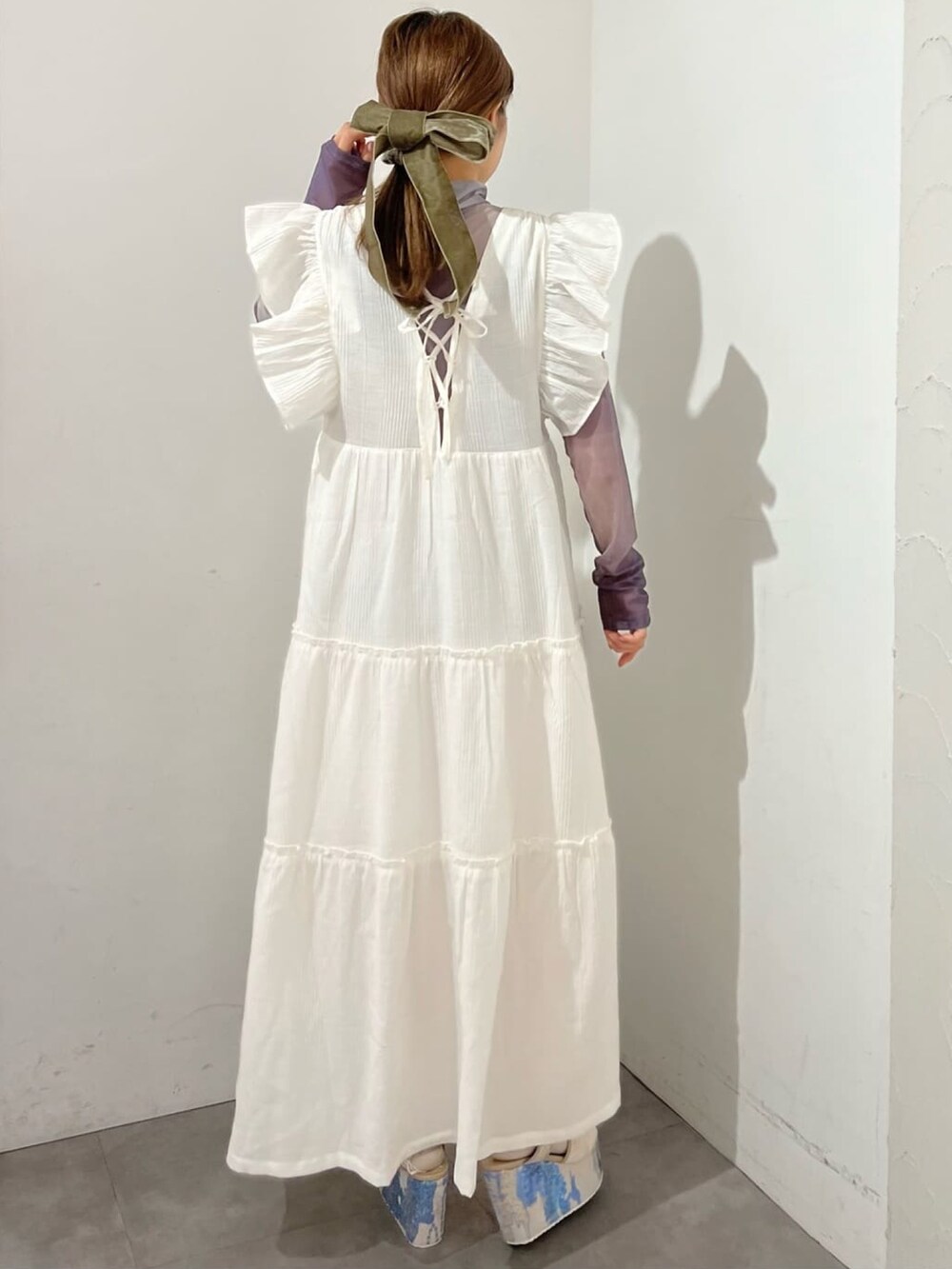 ホワイト系のワンピース、パープル系のTシャツ/カットソー、ブルー系のサンダルを着用したレディースの冬コーディネートの2枚目の写真