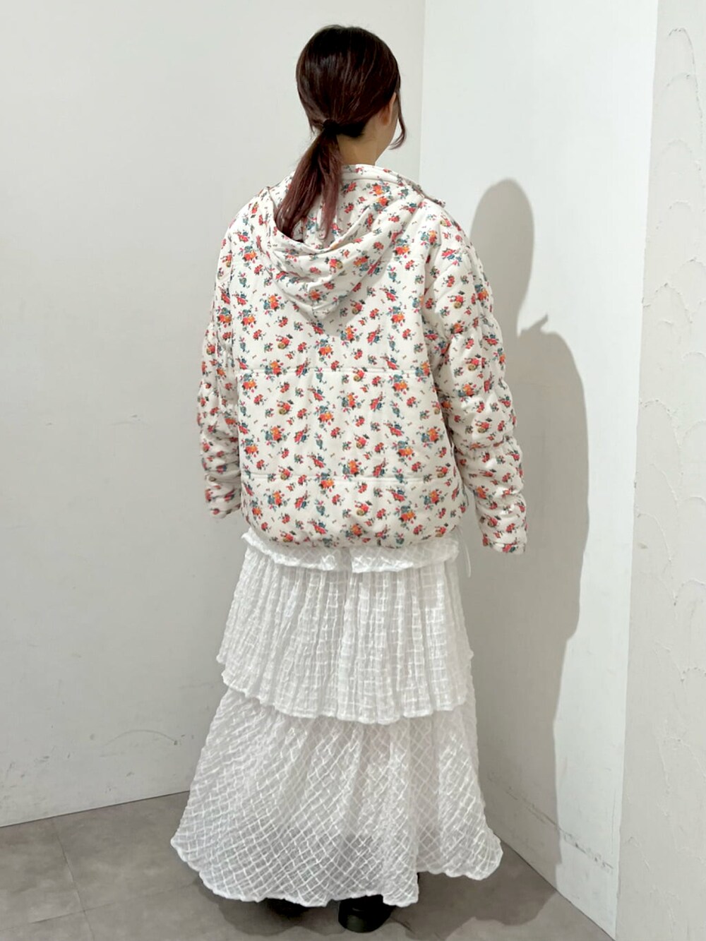 ホワイト系のニット/セーター、ホワイト系のナイロンジャケット、ホワイト系のスカートを着用したレディースの秋コーディネートの2枚目の写真