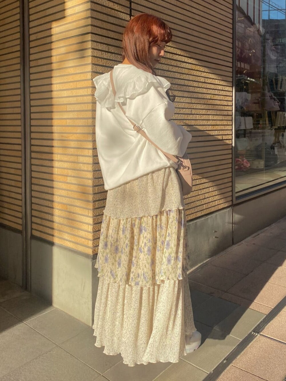 ホワイト系のTシャツ/カットソー、ホワイト系のスカート、ホワイト系のスニーカーを着用したレディースの冬コーディネートの2枚目の写真