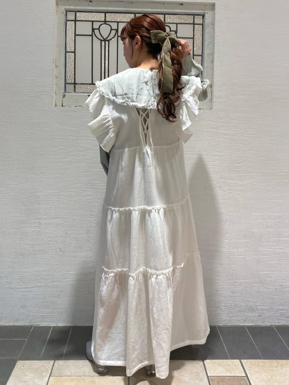 ホワイト系のワンピース、グリーン系のシャツ/ブラウス、ブルー系のパンプスを着用したレディースの冬コーディネートの2枚目の写真