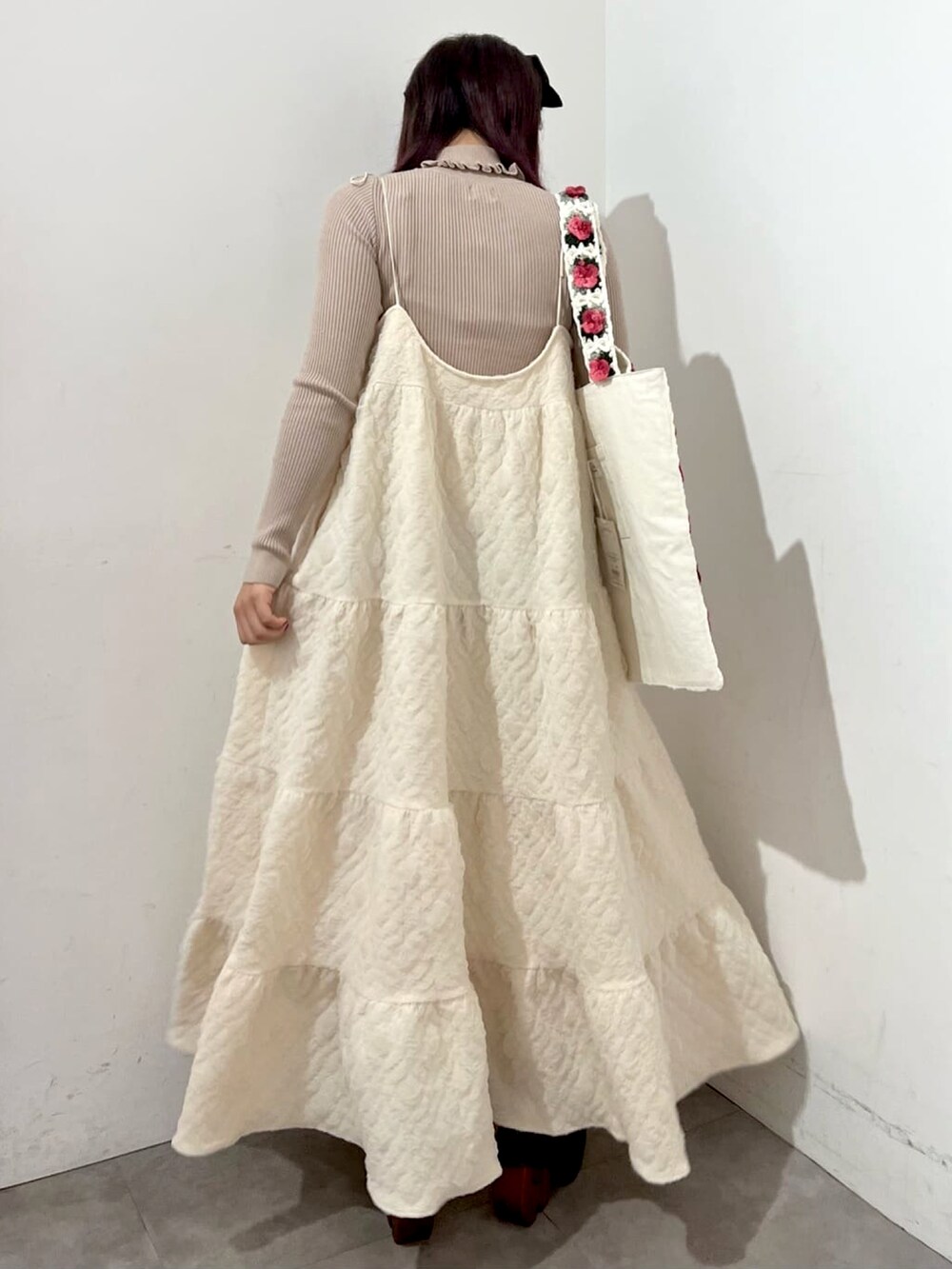 ホワイト系のワンピース、ベージュ系のニット/セーター、ブラウン系のブーツを着用したレディースの秋コーディネートの3枚目の写真