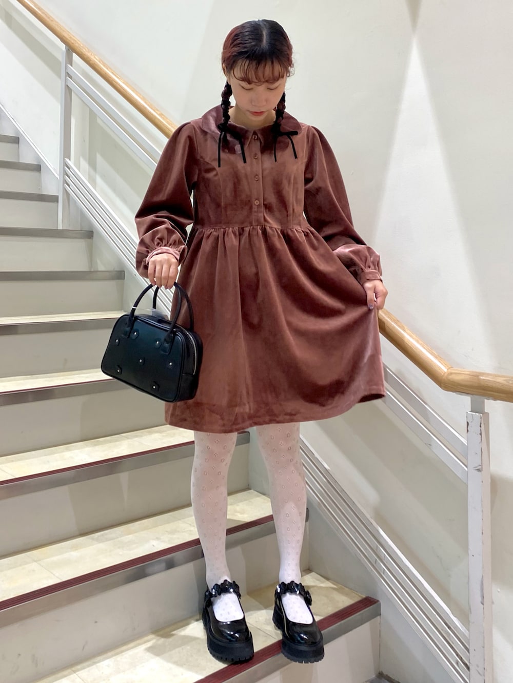 ピンク系のワンピース、ブラック系のローファー、ブラック系のボストンバッグを着用したレディースの秋コーディネートの2枚目の写真