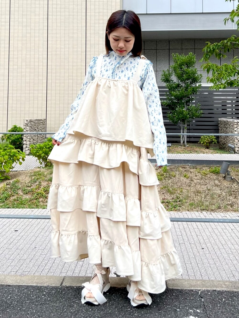 ブルー系のチュニック、ホワイト系のワンピース、ホワイト系のサンダルを着用したレディースの夏コーディネートの2枚目の写真