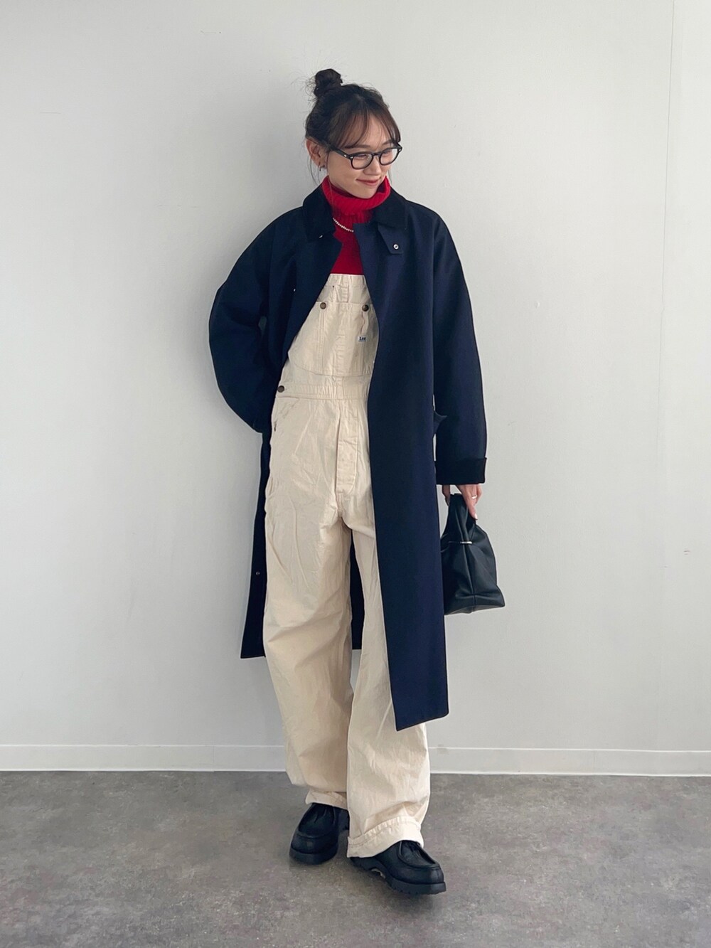 レッド系のニット/セーター、ブルー系のジャケット/アウター、ホワイト系のサロペット/オーバーオールを着用したレディースの冬コーディネートの3枚目の写真