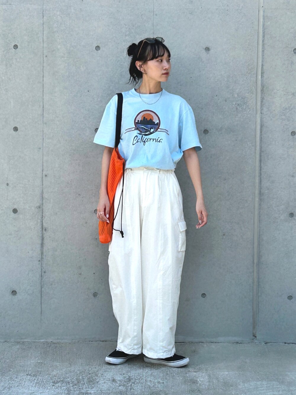 ブルー系のTシャツ/カットソー、ホワイト系のカーゴパンツ、オレンジ系のトートバッグを着用したレディースの夏コーディネートの3枚目の写真