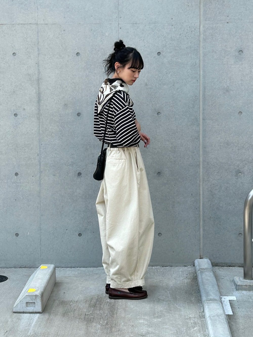 ブラック系のTシャツ/カットソー、ベージュ系のチノパンツ、ブラウン系のローファーを着用したレディースの春コーディネートの2枚目の写真