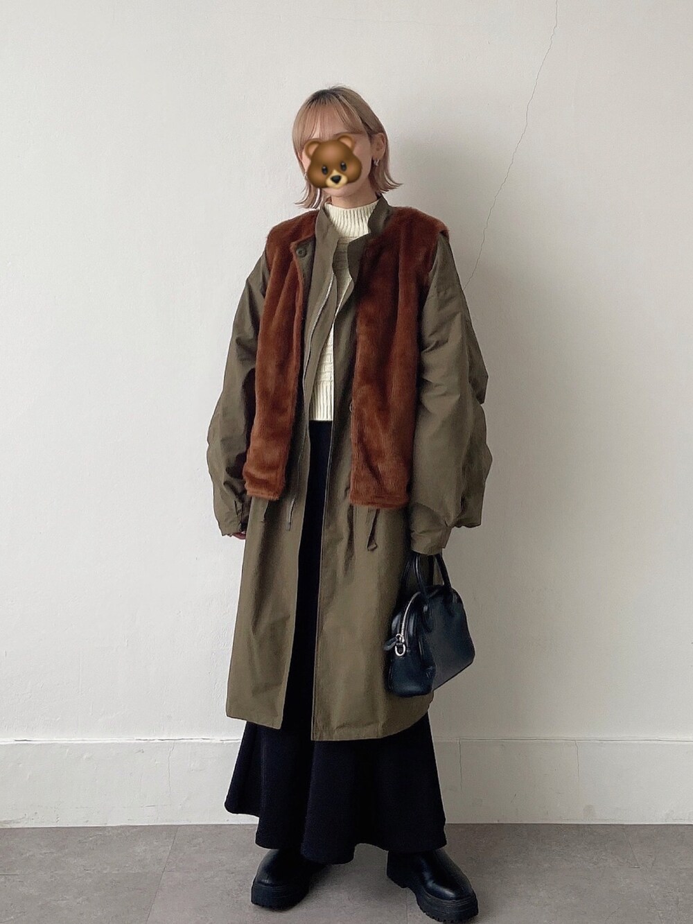 グリーン系のその他アウター、ホワイト系のニット/セーター、ブラック系のスカートを着用したレディースの冬コーディネートの3枚目の写真