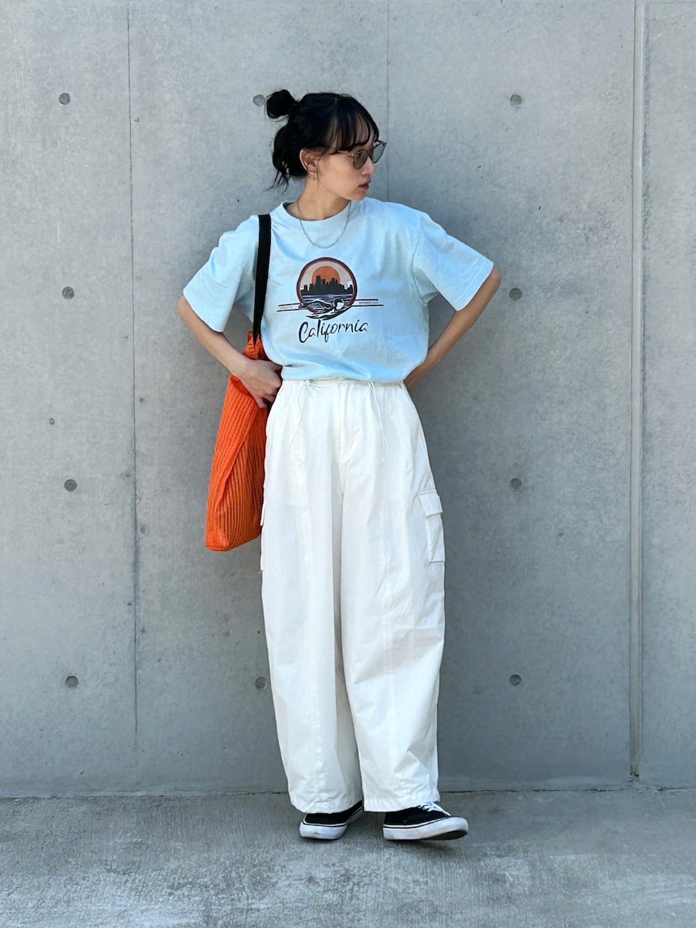 ブルー系のTシャツ/カットソー、ホワイト系のカーゴパンツ、オレンジ系のトートバッグを着用したレディースの夏コーディネートの2枚目の写真