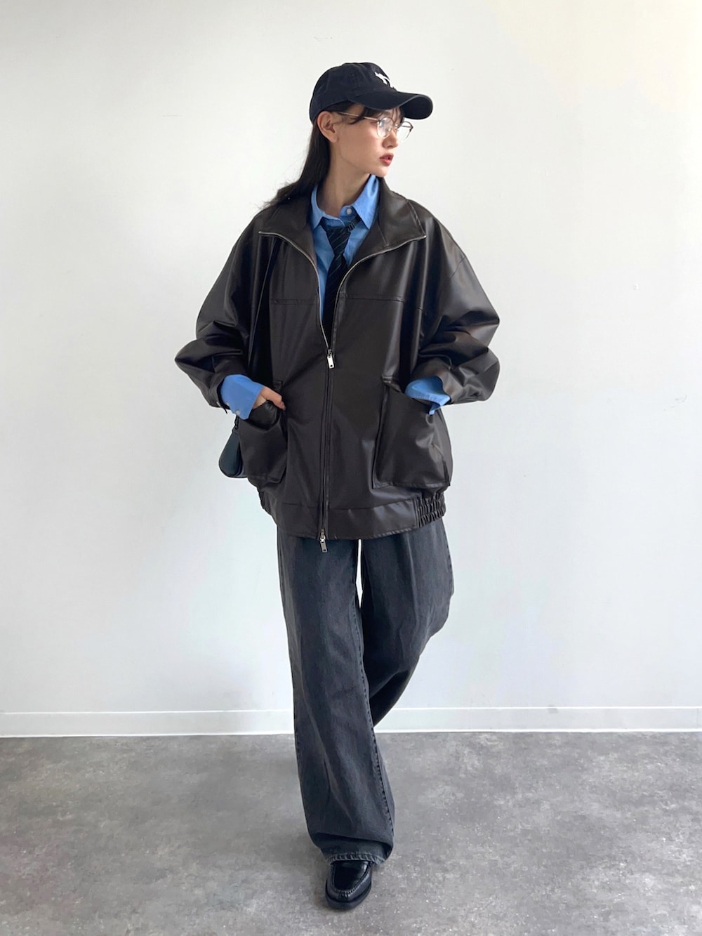 ブラウン系のブルゾン、ブラック系のデニムパンツ、ブルー系のシャツ/ブラウスを着用したレディースの冬コーディネートの2枚目の写真