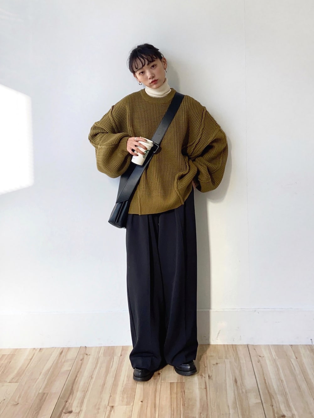 グリーン系のニット/セーター、ブラック系のその他パンツ、ブラック系のショルダーバッグを着用したレディースの秋コーディネートの2枚目の写真