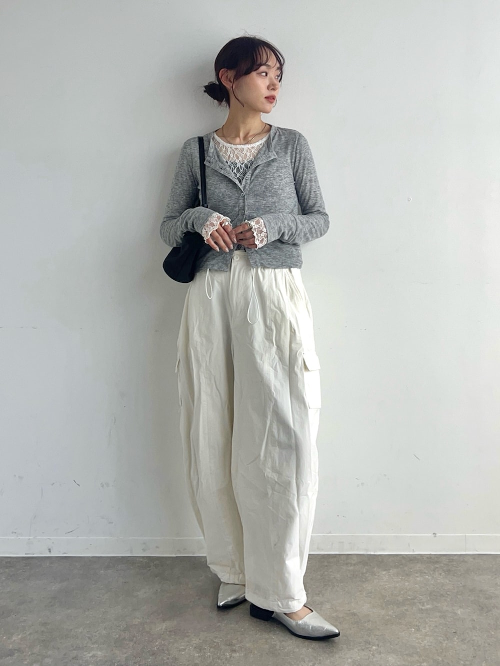 グレー系のカーディガン/ボレロ、ホワイト系のTシャツ/カットソー、ブラック系のハンドバッグを着用したレディースの春コーディネートの2枚目の写真