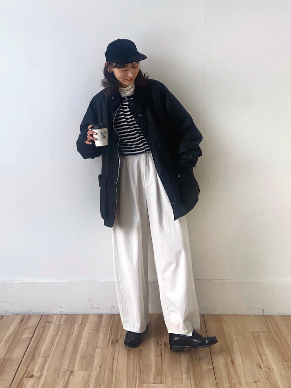 ブラック系のブルゾン、ブラック系のカーディガン/ボレロ、ホワイト系のその他パンツを着用したレディースの冬コーディネートの3枚目の写真