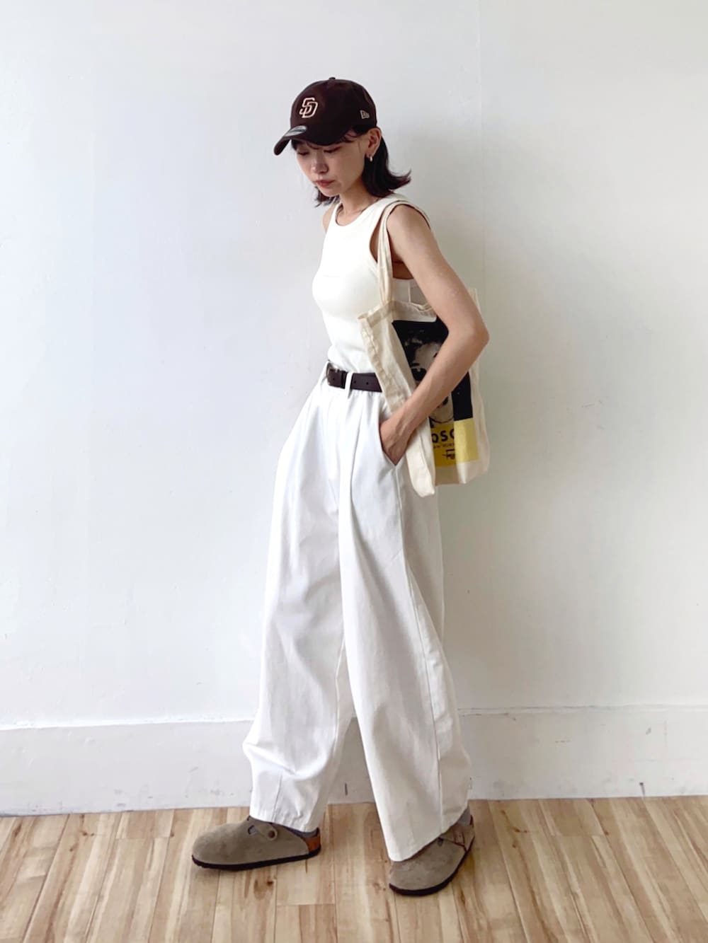 ホワイト系のその他パンツ、ベージュ系のサンダル、ホワイト系のトートバッグを着用したレディースの夏コーディネートの2枚目の写真