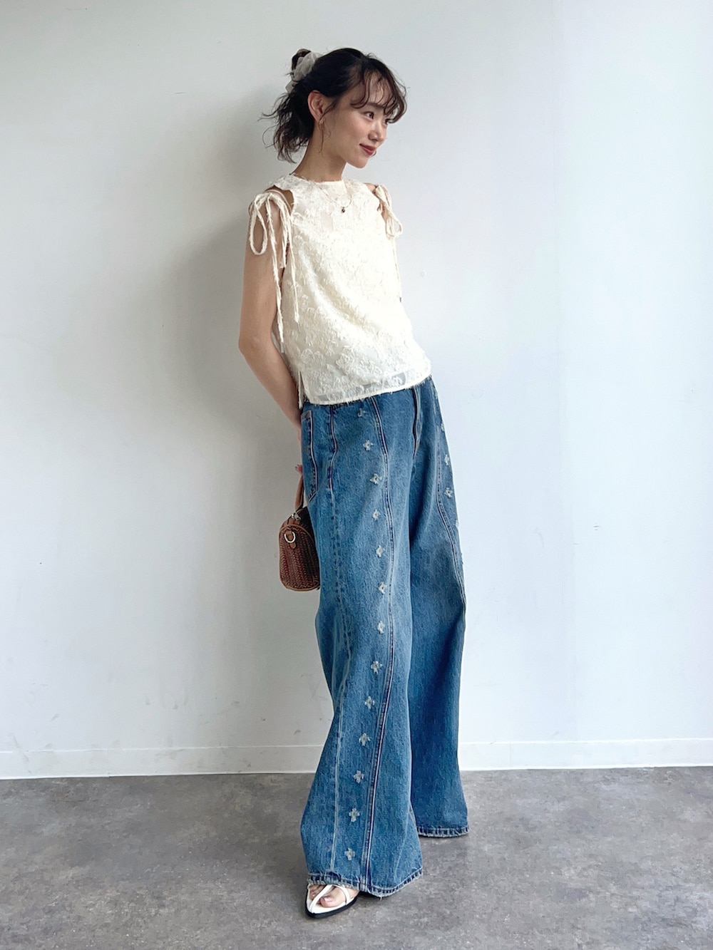 ホワイト系のその他トップス、ブルー系のデニムパンツ、ブラウン系のショルダーバッグを着用したレディースの夏コーディネートの2枚目の写真