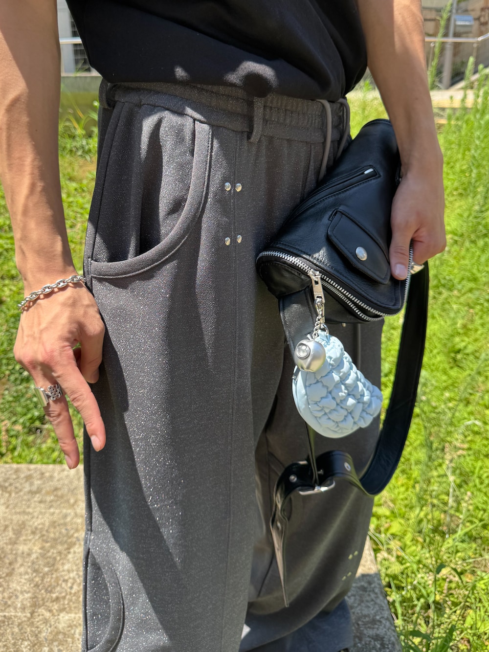 ブラック系のTシャツ/カットソー、ブラック系のショルダーバッグ、ブラウン系のローファーを着用したメンズの夏コーディネートの5枚目の写真