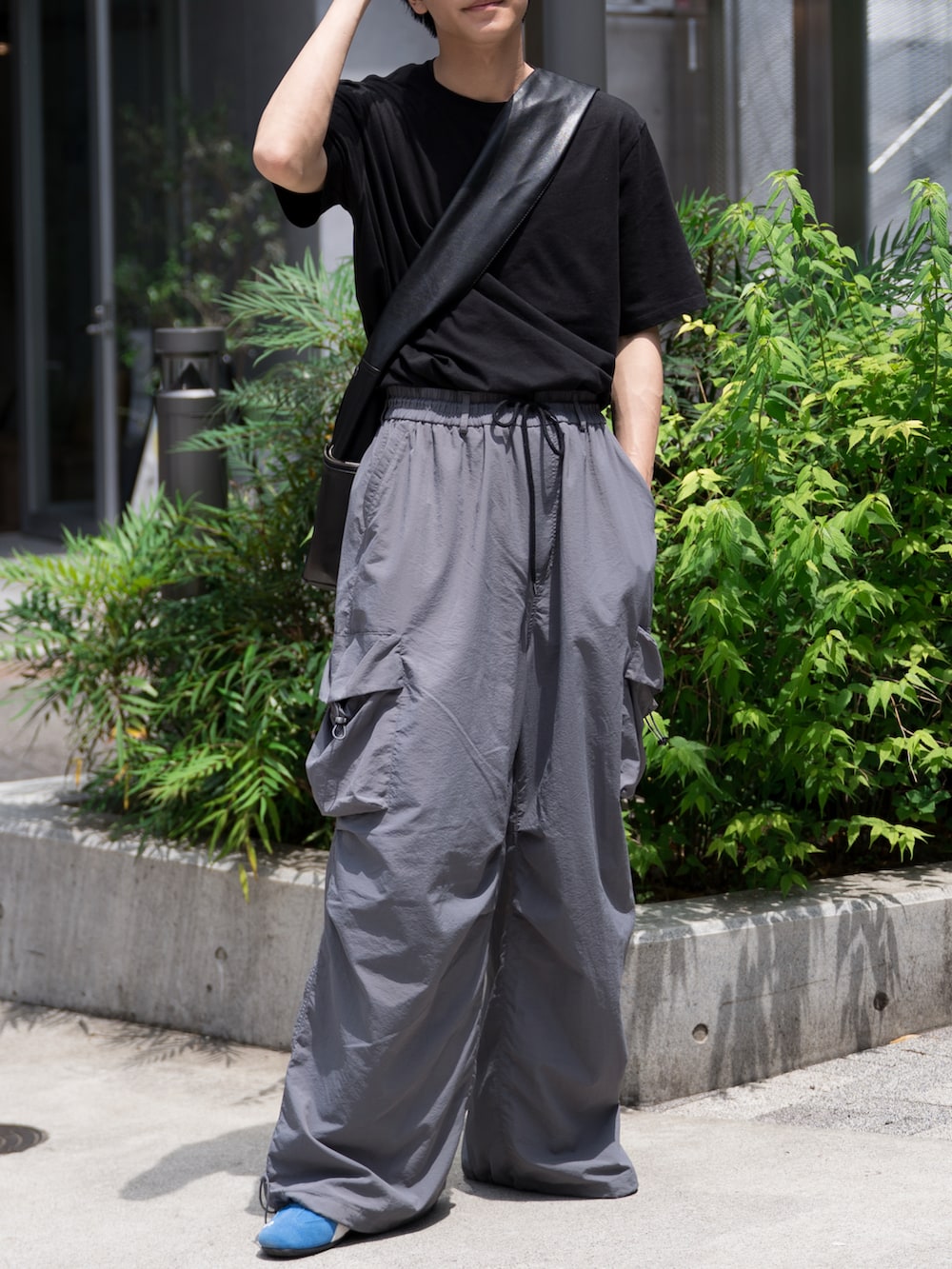 「ショルダーバッグ、夏コーデ、ワイドパンツ、カーゴパンツ、PUMA、黒Tシャツ、タックイン、シンプル、初夏コーデ、カジュアルコーデ」｜「WYM LIDNMのEXTRA FINE COTTON BASIC TEE -SLIM CROPPED FIT-（Tシャツ/カットソー、ブラック系）」を使った、KAIさん（メンズ・183cm）の春コーディネートの4枚目の写真