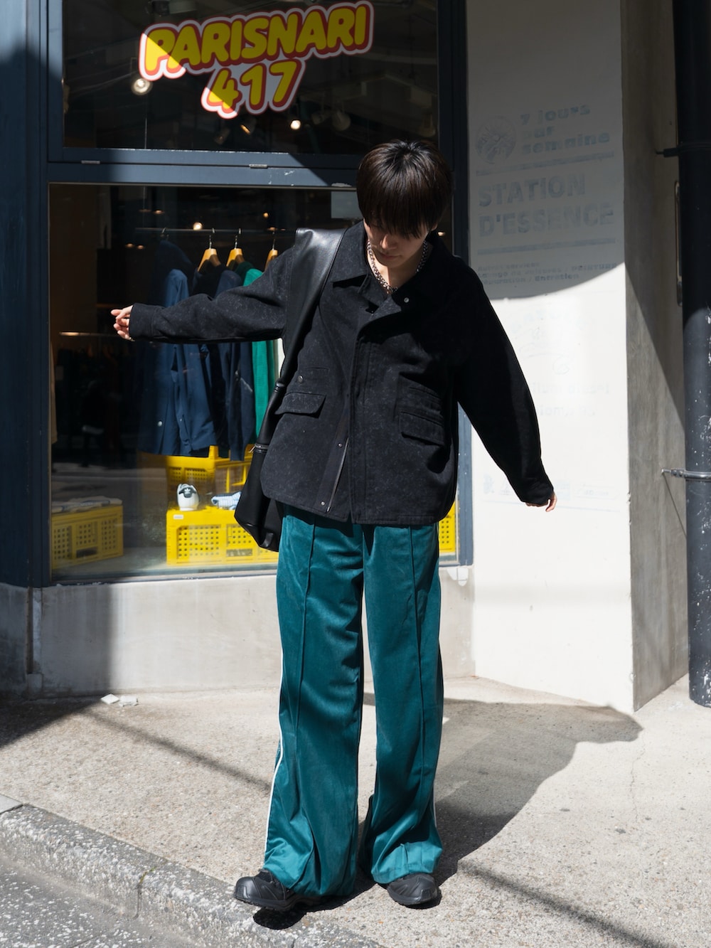 ブラック系のブルゾン、ブルー系のその他パンツ、ブラック系のスニーカーを着用したメンズの春コーディネートの2枚目の写真