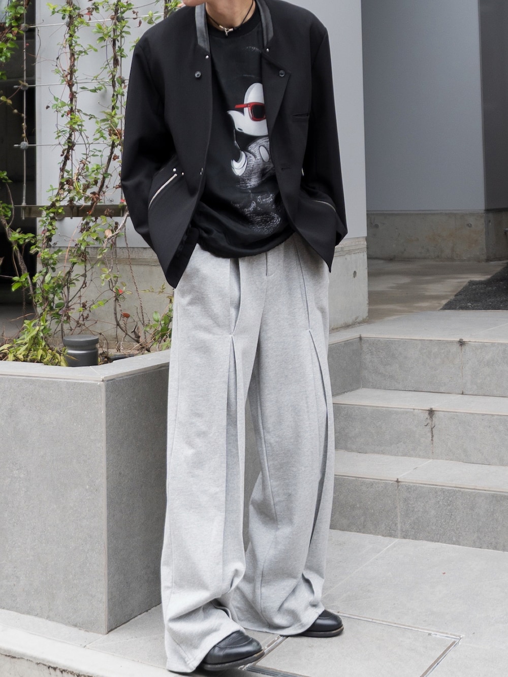 ブラック系のTシャツ/カットソー、グレー系のスウェットパンツ、ブラック系のローファーを着用したメンズの秋コーディネートの3枚目の写真