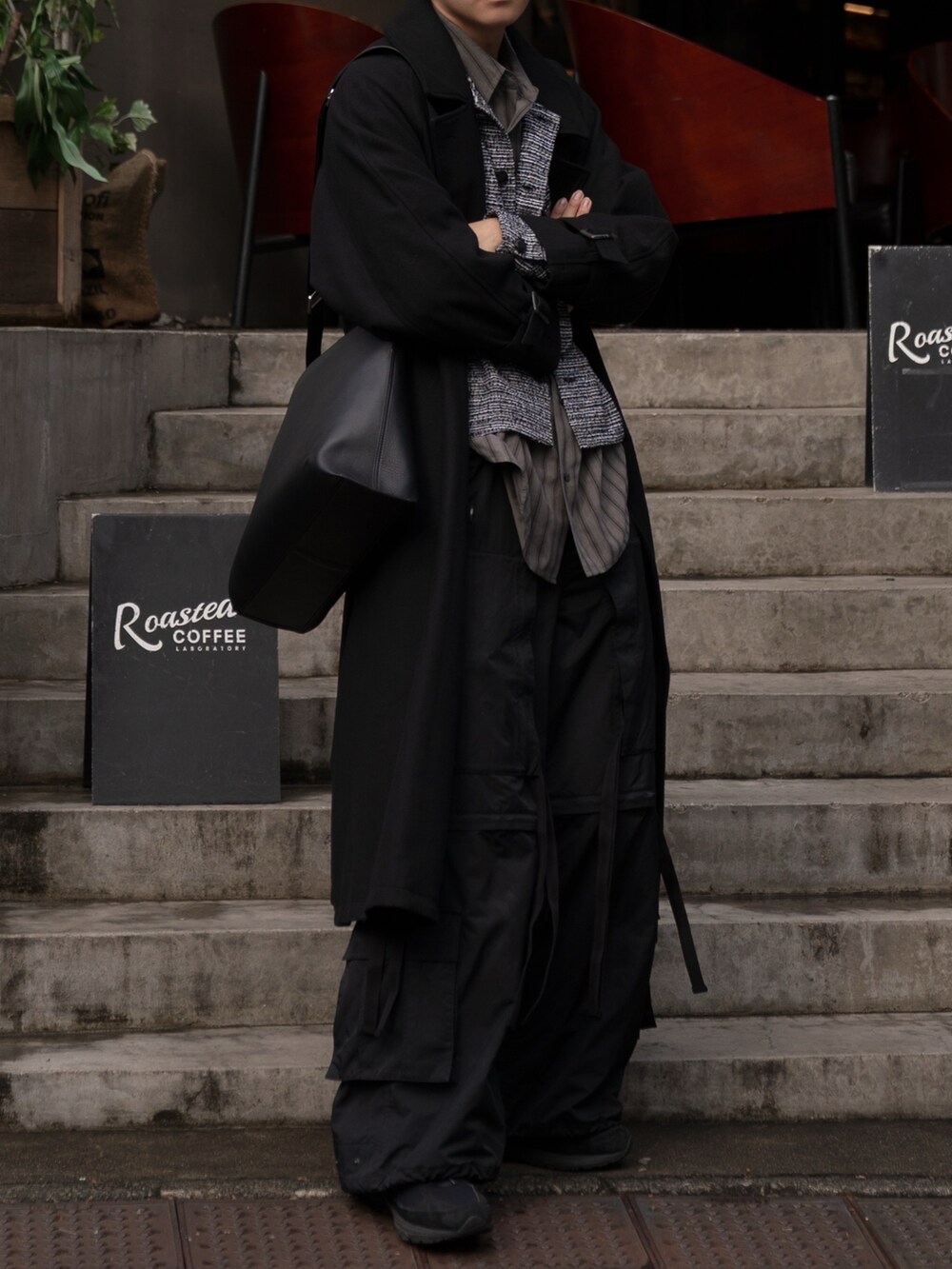 グレー系のノーカラージャケット、ブラック系のステンカラーコート、ブラック系のカーゴパンツを着用したメンズの冬コーディネートの2枚目の写真