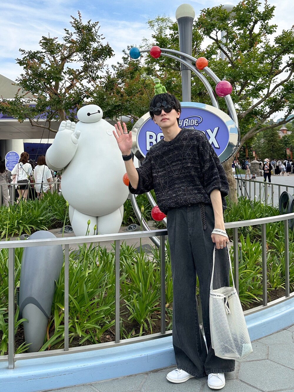 ブラック系のニット/セーター、グレー系のデニムパンツ、ホワイト系のスニーカーを着用したメンズの春コーディネートの3枚目の写真