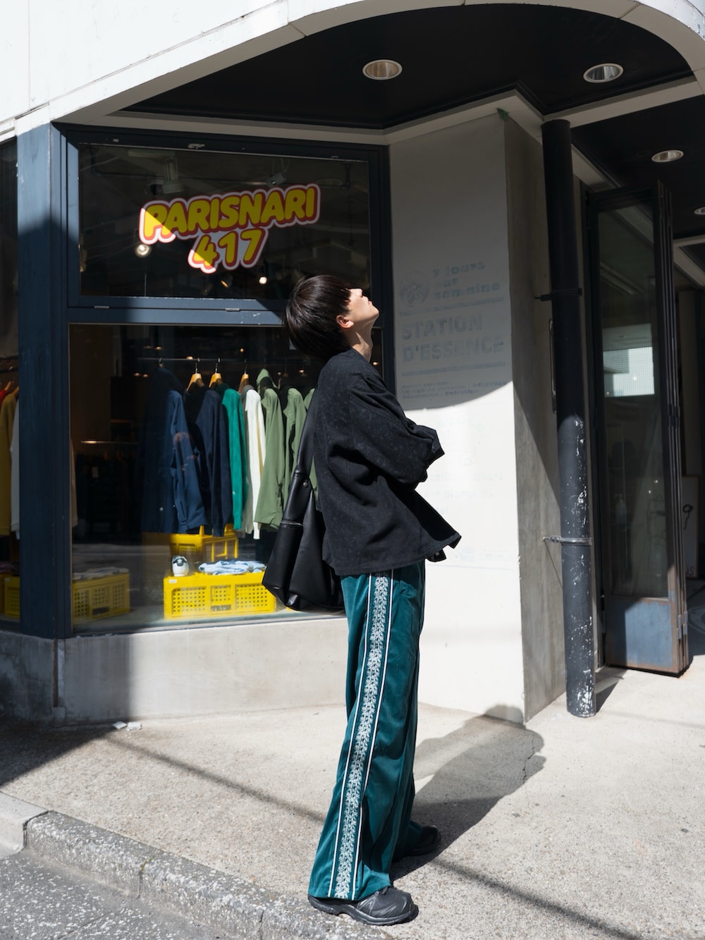 ブラック系のブルゾン、ブルー系のその他パンツ、ブラック系のスニーカーを着用したメンズの春コーディネートの4枚目の写真