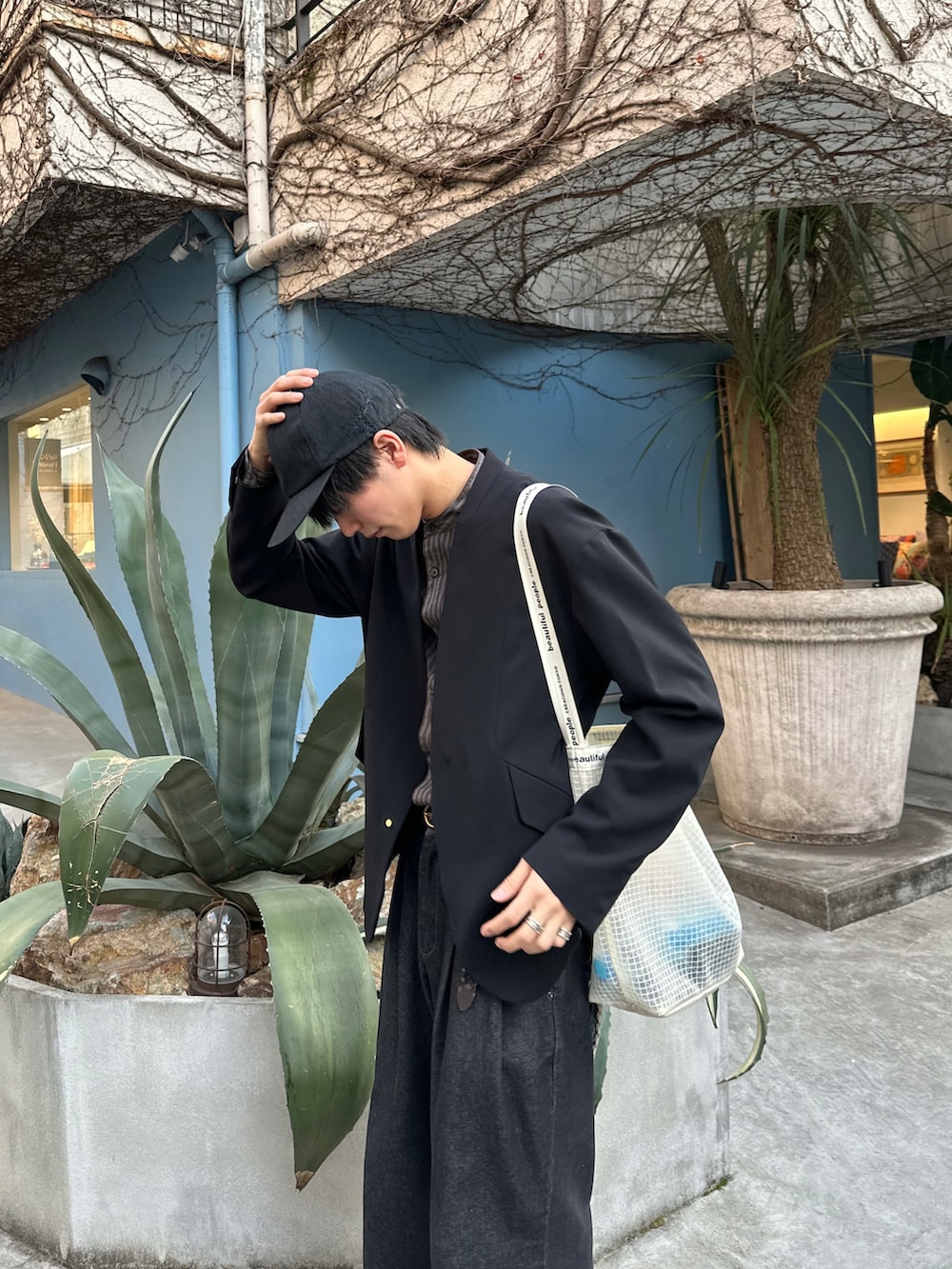 ブラック系のテーラードジャケット、ブラウン系のシャツ/ブラウス、ブラック系のデニムパンツを着用したメンズの春コーディネートの2枚目の写真